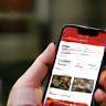 Main tenant un smartphone avec l’app Livraison Gourmande