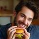 Marc dégustant un burger livré chez lui